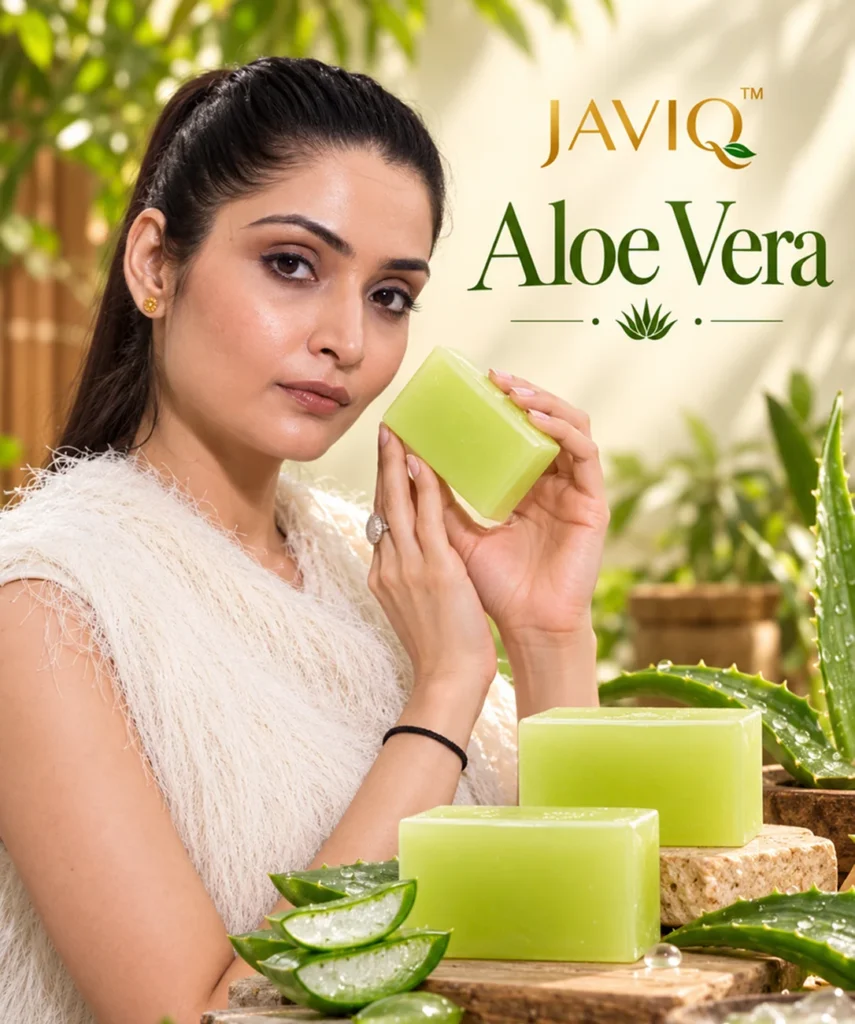 Woman holding a green JAVIQ Aloe Vera handcrafted soap bar beside fresh aloe leaves