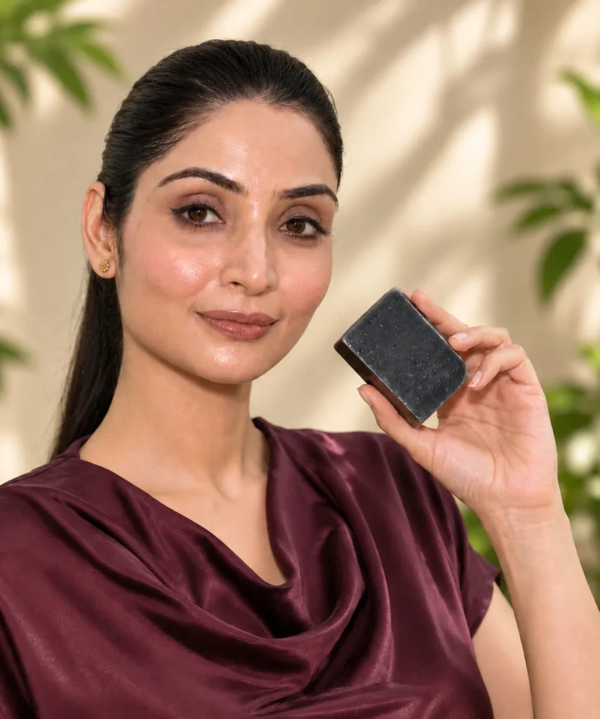 Woman holding a black JAVIQ Activated Charcoal Handcrafted Soap bar